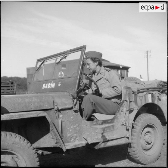 Poste de secours tenu par les Marinettes, ambulancières, dans les environs de Clézentaire. L'enseigne de vaisseau Carsignol, commandant les ambulancières, se trouve au volant de jeep baptisée Badin.