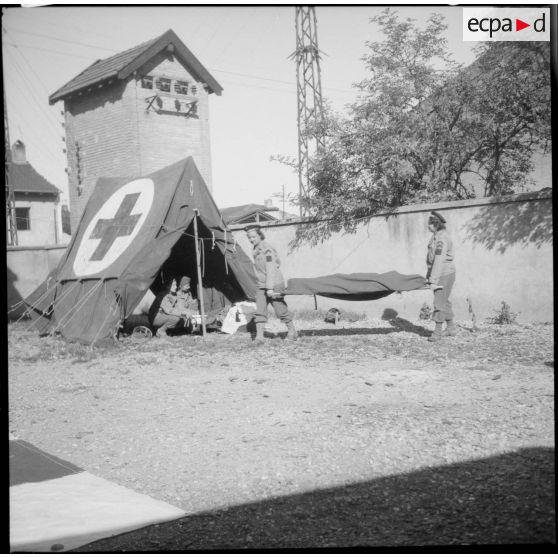 Poste de secours tenu par les Marinettes, ambulancières, dans les environs de Clézentaire. Deux d'entre elles s'entraînent à l'évacuation de blessés.