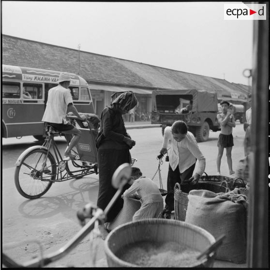 Vendeuse de riz dans une rue commerçante de Saigon.
