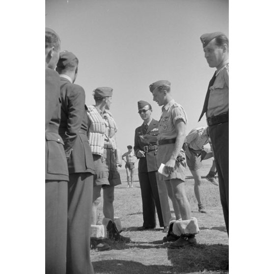Dirigeant un briefing carte à l'appui, le capitaine Av.Gheorghe Iliescu, commandant de l'escadrille 52, en présence du sous-lieutenant Av. Lucaci Mihai, de la 52e escadrille et de pilotes allemands du Jagdgeschwader 4 (JG4).