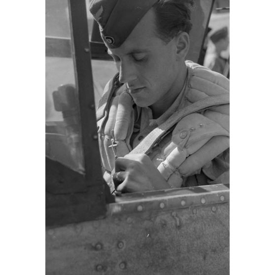 Plan serré sur un pilote allemand aux commandes d'un chasseur Messerschmitt, verrière ouverte.