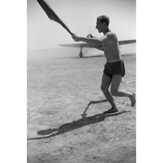 Sur le terrain de Mamaia (Roumanie), un pilote à bord d'un chasseur IAR 80 est aidé lors de son atterrissage.