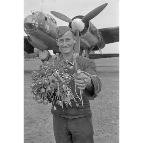 Un mécanicien du 4./KG 51 accueille un équipage de bombardier Junkers Ju-88 avec des fleurs.