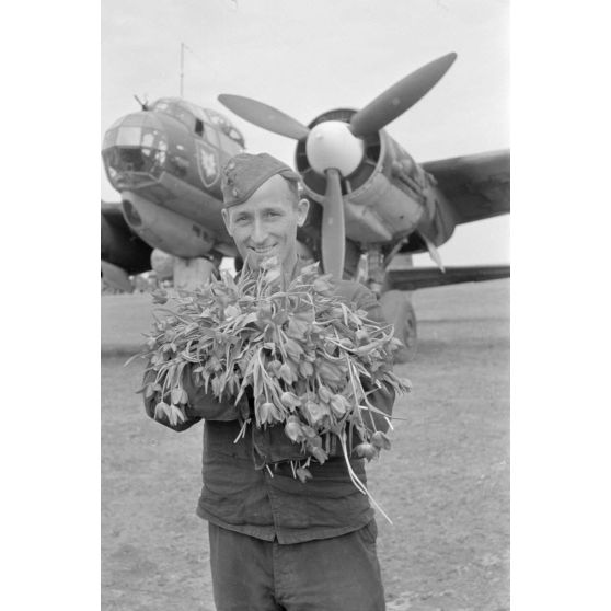 Un mécanicien du 4./KG 51 accueille un équipage de bombardier Junkers Ju-88 avec des fleurs.