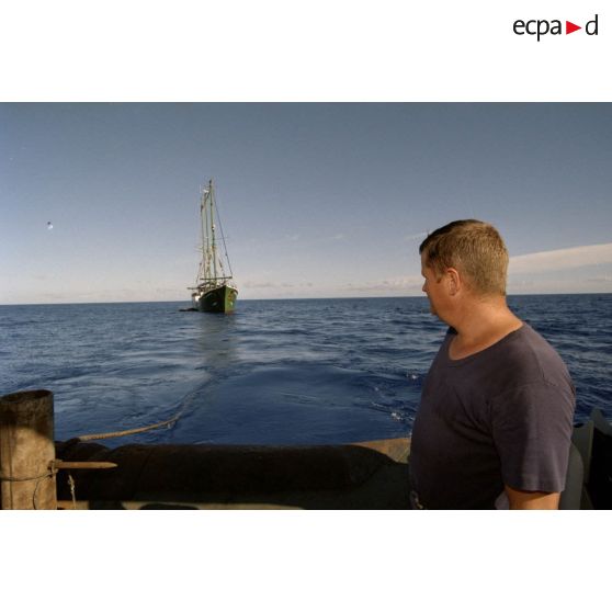 Un premier-maître vérifie le câble qui relie le navire Rainbow Warrior II de Greenpeace arraisonné au remorqueur-ravitailleur Revi (A635) lors du remorquage vers Moruroa.
