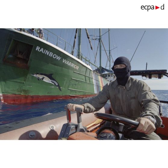 Un second-maître du commando marine Hubert pilote un zodiac et patrouille à côté du navire Rainbow Warrior II de Greenpeace après son arraisonnement. Dessin de dauphin sur l'étrave du navire.