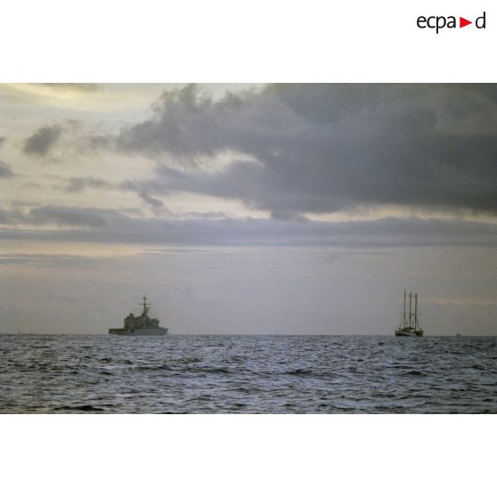 Le 9 juillet au matin, le navire Rainbow Warrior II de l'association Greenpeace, en vue de la passe de Moruroa dans les eaux territoriales françaises, zone interdite, est escorté par la frégate Vendémiaire (F734).