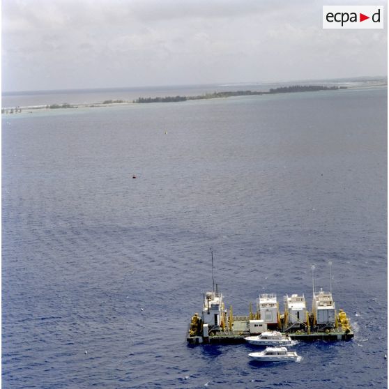 Vue aérienne d'une barge d’enregistrement et de mesure (BEM) et de vedettes du Commissariat à l’énergie atomique (CEA) dans le lagon de l'atoll de Moruroa.