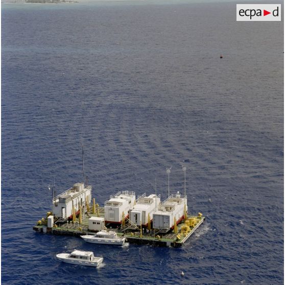 Vue aérienne d'une barge d’enregistrement et de mesure (BEM) et de vedettes du Commissariat à l’énergie atomique (CEA) dans le lagon de l'atoll de Moruroa.