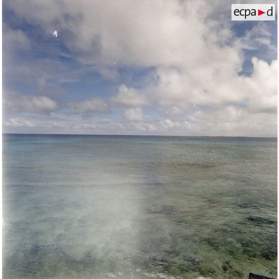 La mer depuis l'atoll de Moruroa sur un fond de ciel nuageux.