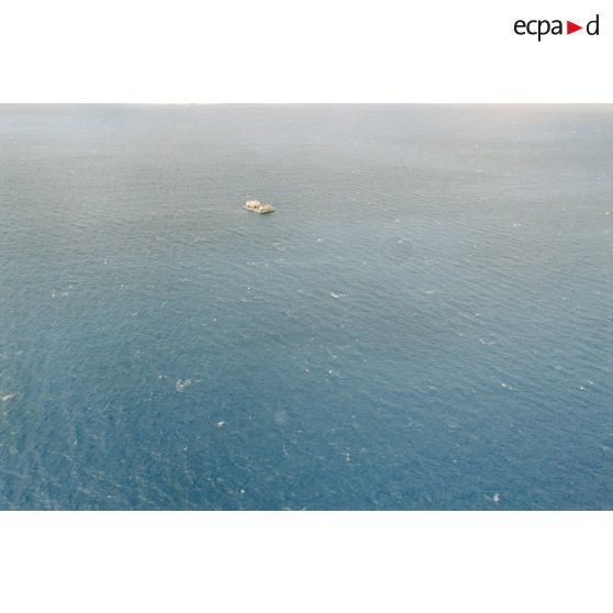 Vue aérienne de la zone de tir et de la barge d’enregistrement et de mesure une heure après le troisième tir souterrain Aepytos du 27 octobre 1995 lors de la dernière campagne d'essais nucléaires dans le lagon de l'atoll de Moruroa.