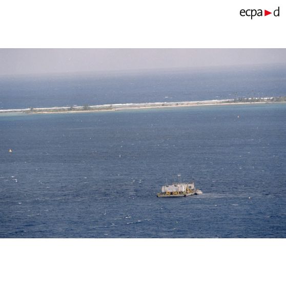 Vue aérienne de la zone de tir et de la barge d’enregistrement et de mesure MTCT 02 / EM03 / CTDS 1 du commissariat à l'énergie atomique (CEA) une heure après le troisième tir souterrain Aepytos du 27 octobre 1995 lors de la dernière campagne d'essais nucléaires dans le lagon de l'atoll de Moruroa.