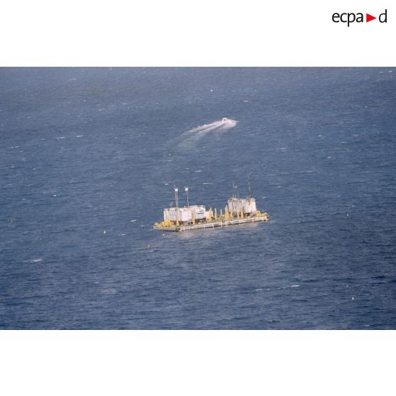 Vue aérienne de la barge d’enregistrement et de mesure MTCT 02 / EM03 / CTDS 1 du commissariat à l'énergie atomique (CEA) une heure après le troisième tir souterrain Aepytos du 27 octobre 1995 lors de la dernière campagne d'essais nucléaires dans le lagon de l'atoll de Moruroa.