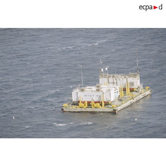 Vue aérienne de la barge d’enregistrement et de mesure MTCT 02 / EM03 / CTDS 1 du commissariat à l'énergie atomique (CEA) une heure après le troisième tir souterrain Aepytos du 27 octobre 1995 lors de la dernière campagne d'essais nucléaires dans le lagon de l'atoll de Moruroa.