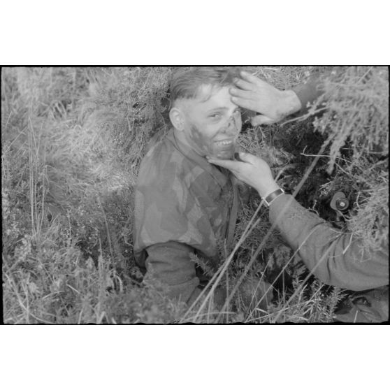 Dans les monts d'Arrée, un parachutiste allemand de la 3.Fallschirmjäger.Division recouvert d'un camouflage.