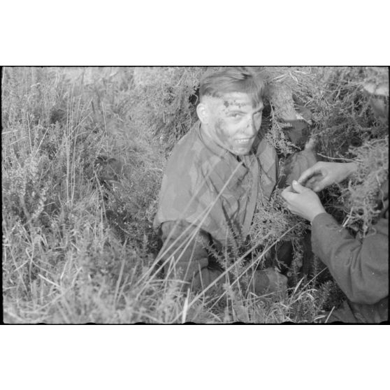 Dans les monts d'Arrée, un parachutiste allemand de la 3.Fallschirmjäger.Division recouvert d'un camouflage.