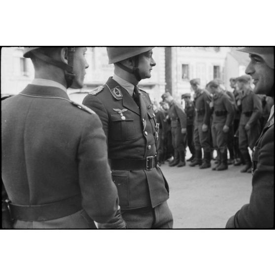 Sur la place de Huelgoat (Finistère centre), des parachutistes allemands de la 3.Fallschirmjäger.Division règlent les derniers détails avant une prise d'armes.