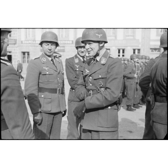 Sur la place de Huelgoat (Finistère centre), des parachutistes allemands de la 3.Fallschirmjäger.Division règlent les derniers détails avant une prise d'armes.