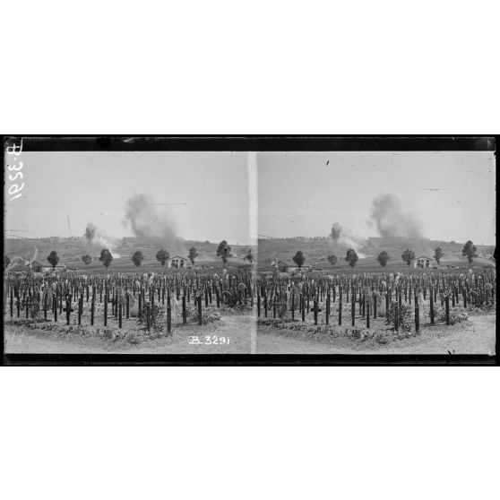 Devant Verdun, sur les pentes du fort St Michel, éclatements d’obus, au 1er plan cimetière militaire. [légende d’origine]