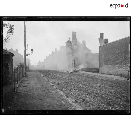 [Ruines et maison en feu dans la ville de Vouziers.]