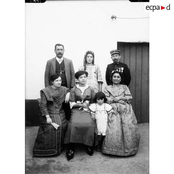 1009. Groupe famille. La fille tient le petit chien. [légende d'origine]