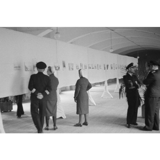 Des officiers de la marine allemande (Kriegsmarine) visitent une exposition de peintures (gouache et aquarelle).