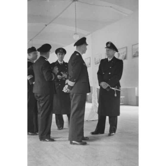 Des officiers de la marine allemande (Kriegsmarine) visitent une exposition de peintures (gouache et aquarelle).