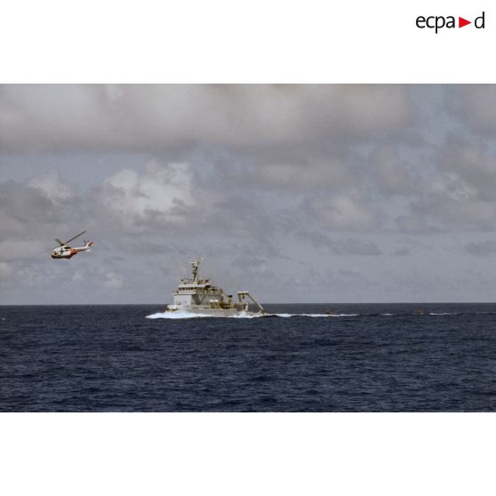 Exercice d'arraisonnement en haute mer du remorqueur-ravitailleur RR Revi (A635) par le commando Jaubert en zodiac. Survol par un hélicoptère Super Puma de l'ETOM 82.