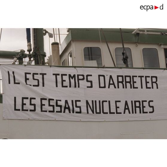 Banderole "il est temps d'arrêter les essais nucléaires" à bord du navire Rainbow Warrior 2  de l'association Greenpeace à quai dans le port de Papeete.