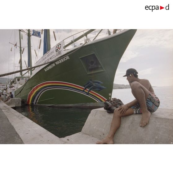 Navire Rainbow Warrior 2 de l'association Greenpeace à quai à Papeete avec des sympathisants. Banderole "patoi te paura atomi i roto i te moana patitifa, le Pacifique libre du nucléaire".