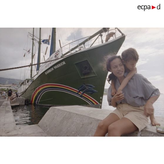 Navire Rainbow Warrior 2 de l'association Greenpeace à quai à Papeete avec des sympathisants. Banderole "patoi te paura atomi i roto i te moana patitifa, le Pacifique libre du nucléaire".