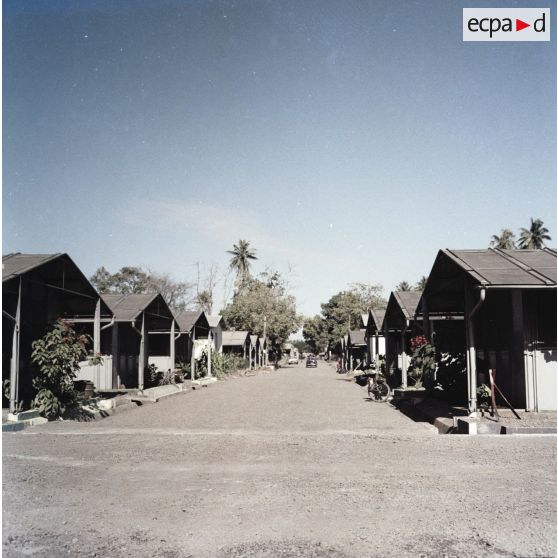 Logements préfabriqués, voirie et système de canalisation dans la zone de vie d'un camp militaire, peut-être à Arue.