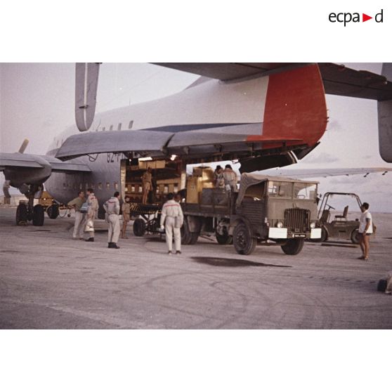 Déchargement d'un avion de transport Bréguet Deux Ponts transportant du fret pour le centre d'expérimentations du Pacifique (CEP) à l'aéroport d'un atoll de Polynésie française.