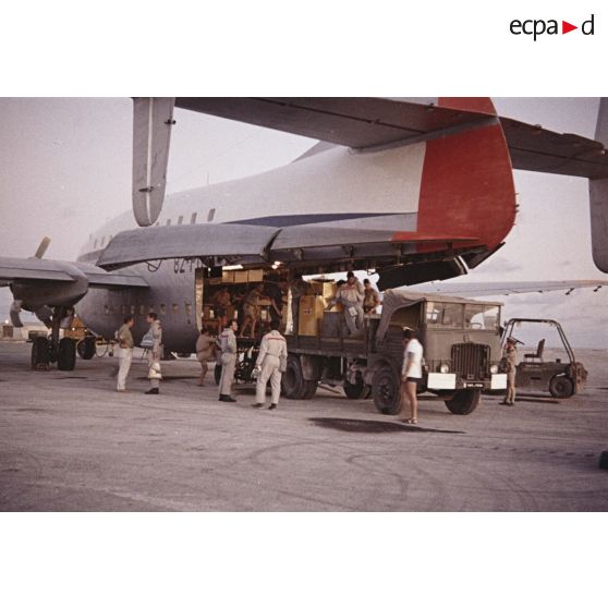 Déchargement d'un avion de transport Bréguet Deux Ponts transportant du fret pour le centre d'expérimentations du Pacifique (CEP) à l'aéroport d'un atoll de Polynésie française.