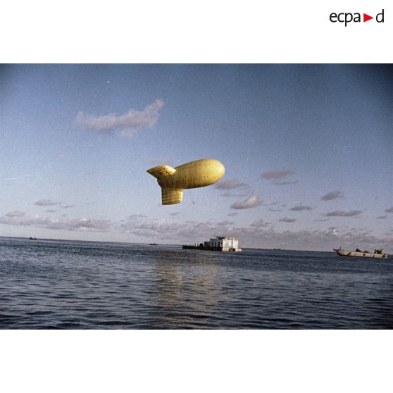 Un ballon captif conduit sur le lagon de Moruroa auprès d'une barge par un engin de débarquement d'infanterie et de chars (EDIC) pour amarrage.