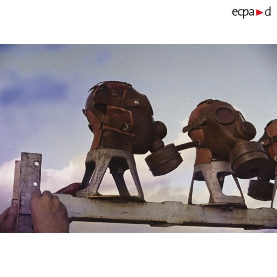 Près du poste d’enregistrement avancé (PEA) Denise, des personnels relèvent des masques à gaz exposés pour étude des effets des tirs par la section technique de l’armée de terre (STAT).