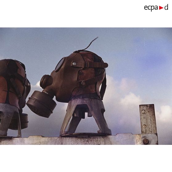 Près du poste d’enregistrement avancé (PEA) Denise, des personnels relèvent des masques à gaz exposés pour étude des effets des tirs par la section technique de l’armée de terre (STAT).