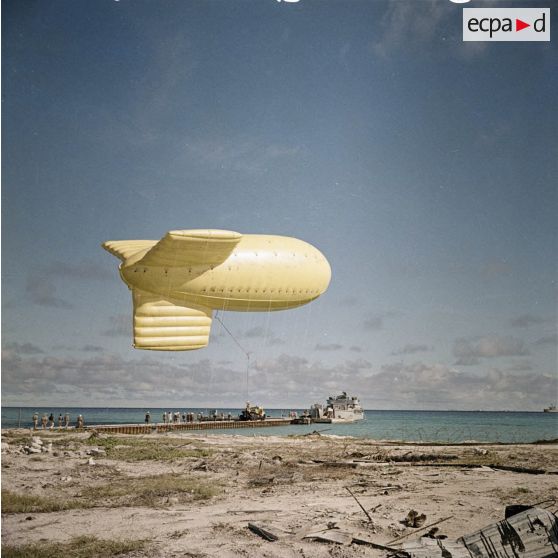 Ballon gonflé acheminé par camion vers l'engin de débarquement d'infanterie et de chars (EDIC) L9091 près du site du poste de commande de tir (PCT) Anémone probablement pour le tir Antarès du Centre d'expérimentations du Pacifique (CEP) sous ballon à Moruroa (27 juin 1967).