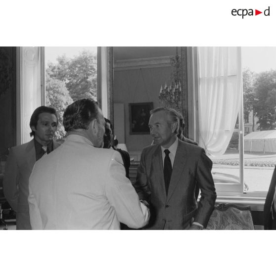 Charles Hernu, ministre de la Défense, entouré de membres de son cabinet, reçoit en audience une délégation d'élus de la Polynésie française conduite par Gaston Flosse qu'il salue.