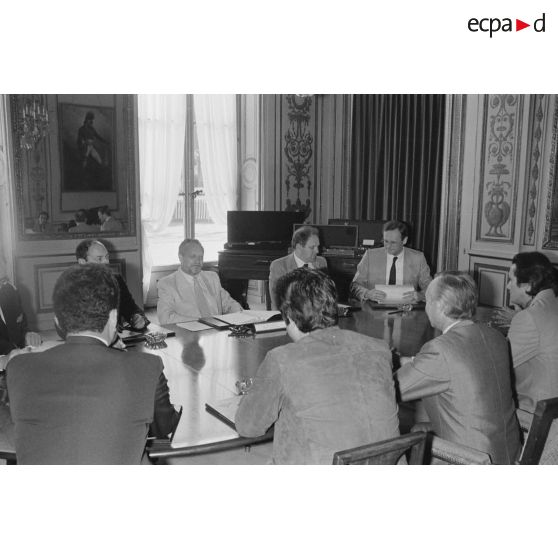 Charles Hernu, ministre de la Défense, entouré de membres de son cabinet, reçoit en audience une délégation d'élus de la Polynésie française conduite par Gaston Flosse (de dos).