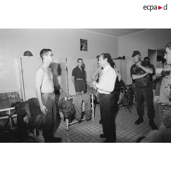 Après la pluie, visite dans une chambrée du régiment d'infanterie de marine du Pacifique-Polynésie (RIMaP-P) de Georges Lemoine, secrétaire d'Etat à la Défense, en présence d'un capitaine et du lieutenant-colonel.