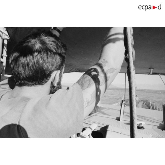 Sortie en mer du patrouilleur La Combattante P730 pour une course de pirogues à l'île de Moorea. Matelot arborant un tatouage.