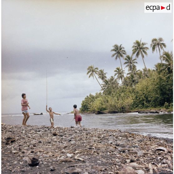 Des garçons pêchent à l'embouchure de la rivière, peut-être à Tahiti.