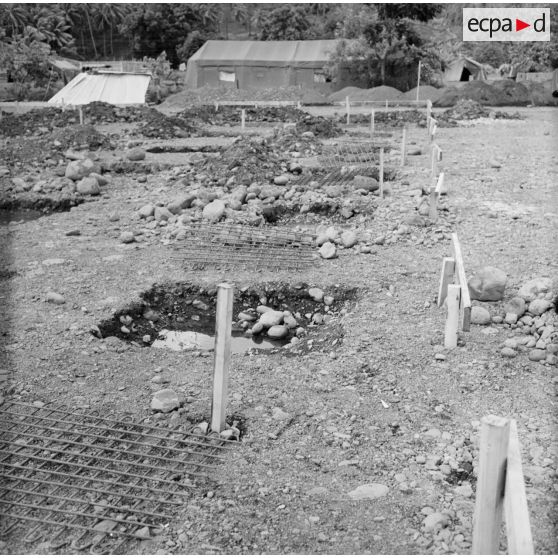 Construction et maçonnerie, bétonnage. Mise en place des infrastructures. Tente. Peut-être la construction du camp d'Arue, vers 1963-1964.