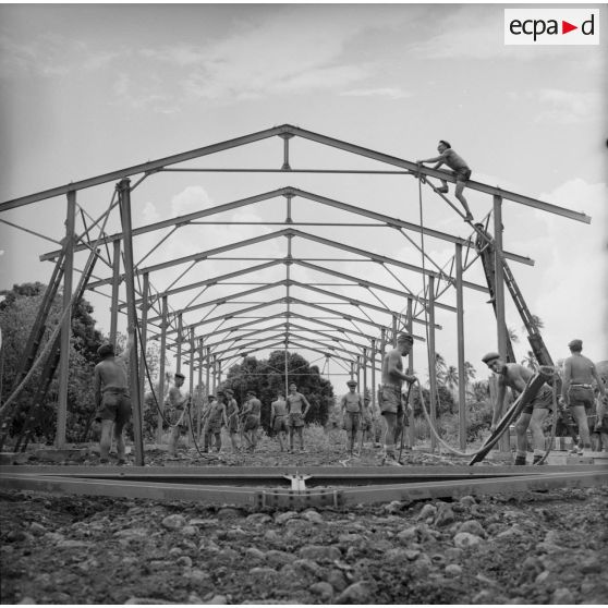 Montage de la structure métallique d'un hangar. Militaires du 5e régiment mixte du Pacifique (5e RMP). Peut-être la construction du camp d'Arue, vers 1963-1964.