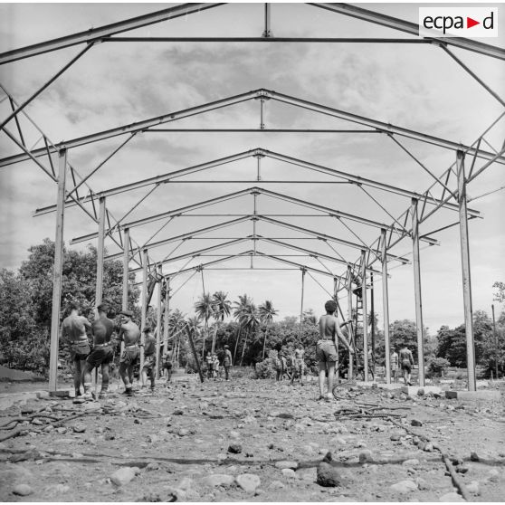 Montage de la structure métallique d'un hangar. Militaires du 5e régiment mixte du Pacifique (5e RMP). Peut-être la construction du camp d'Arue, vers 1963-1964.
