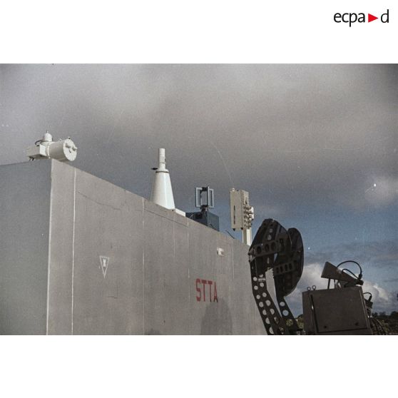 Appareils du Centre d'expérimentations du Pacifique (CEP) sur le toit d'un container portant l'inscription "STTA" et antennes sur l'atoll de Moruroa.