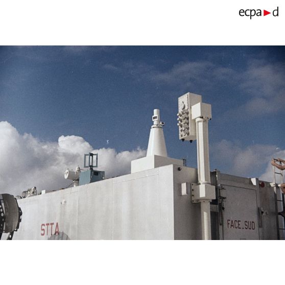 Appareils du Centre d'expérimentations du Pacifique (CEP) sur le toit d'un container portant l'inscription "STTA" et antennes sur l'atoll de Moruroa.