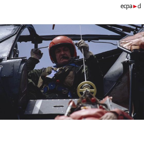 Portrait d'un militaire sécurisant l'hélitreuillage d'un personnel sur le pont du ferry Corse depuis l'hélicoptère Alouette-III de l'aéronavale.