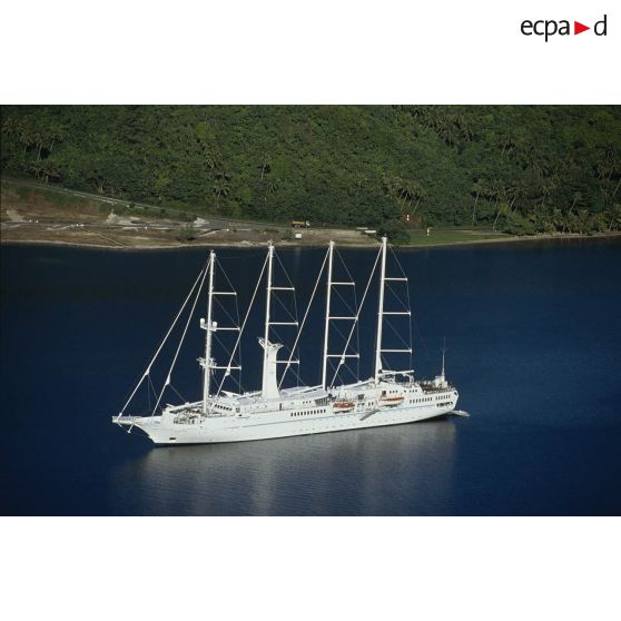 Paysage polynésien. Goélette à quatre mâts Wind Song peut-être dans la baie de Cook à Moorea. [Description en cours]